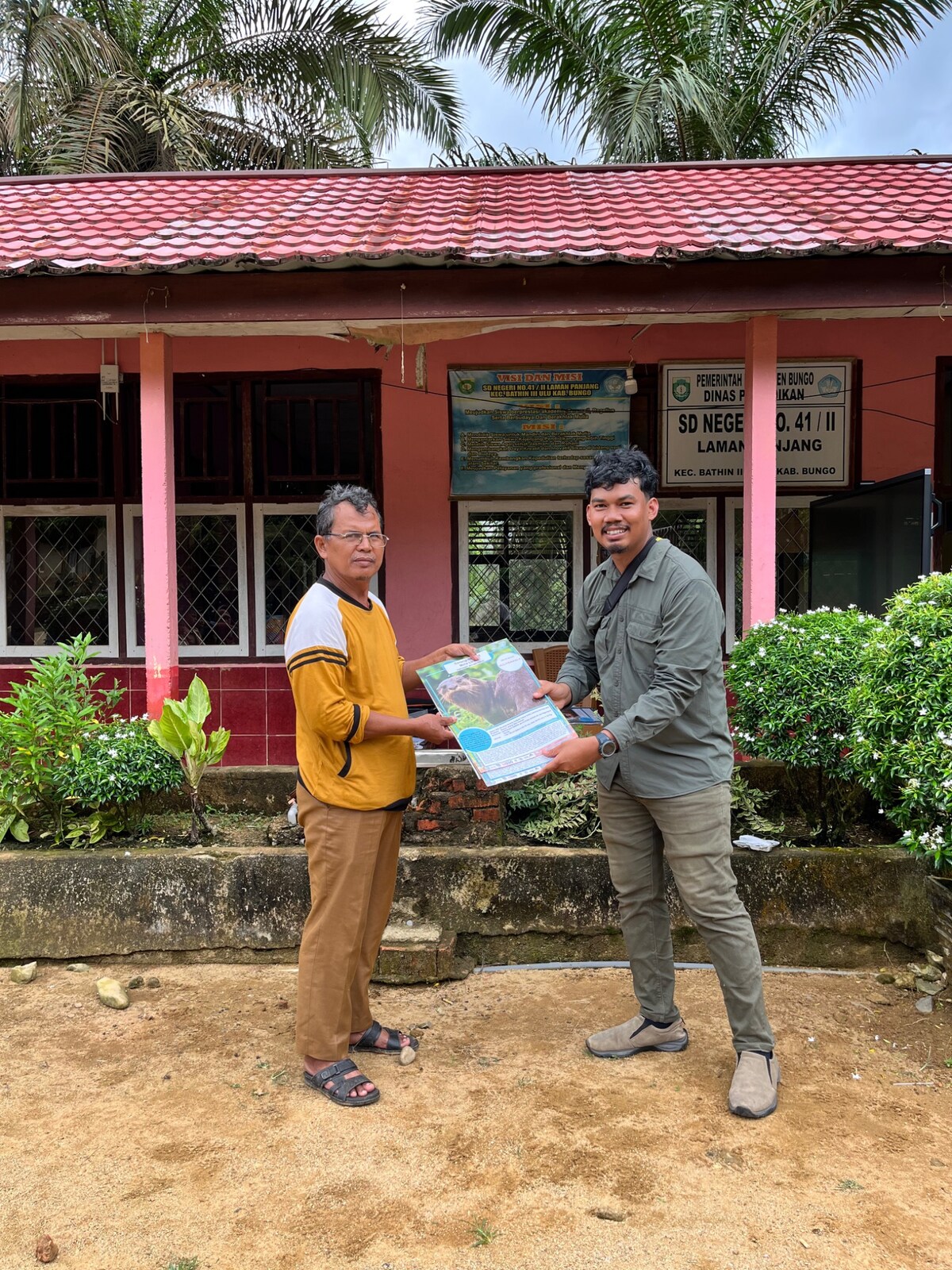Penyerahan poster edukasi konservasi berang-berang kepada pihak sekolah
